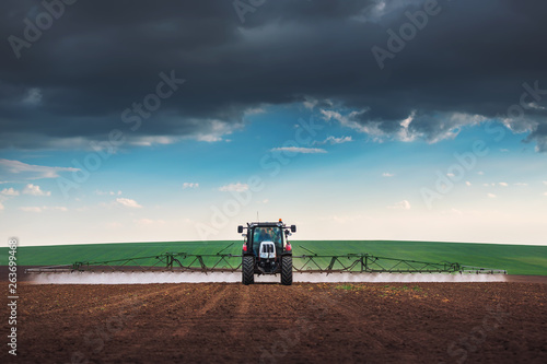 Fotomural Farming tractor plowing and spraying on field