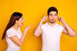© deagreez - Close up side profile photo two beautiful people she her he him his blaming yell fault aggression awful roll eyes up hide ears fingers ignore wear casual white t-shirts isolated yellow background