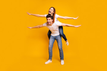 Full length body size view portrait of his he her she two nice attractive cheerful optimistic people having fun trip fly vacation holiday isolated over vivid shine bright yellow background