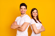 © deagreez - Close up photo beautiful she her he him his pair stand back side close teamwork self-confident professionals specialists work job reliable workers wear casual white t-shirts isolated yellow background
