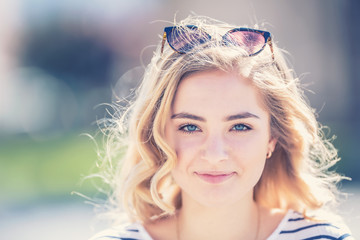 Summer portrait of a happy young girl with curly hair and wonderful smile