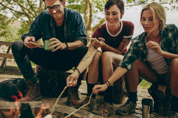 Wall Mural - Friends toasting food on bonfire in the countryside