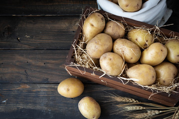 Organic Raw Potatoes in a Wooden Crate in Straw