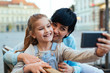 © cherryandbees - mother and her daughter taking selfie with cellphone outdoor in the city