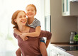 © JenkoAtaman - family mother and child daughter hugging in kitchen