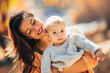 © Mediteraneo - Happy family mother and baby son playing and laughing on autumn walk