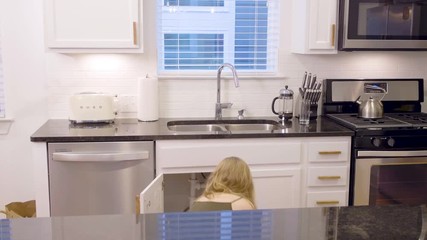 Over the counter view of a woman grabbing her plumbing tools and going under the sink, 23.98 fps.