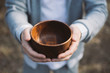 © badyur - Men hand holding empty wooden bowl.