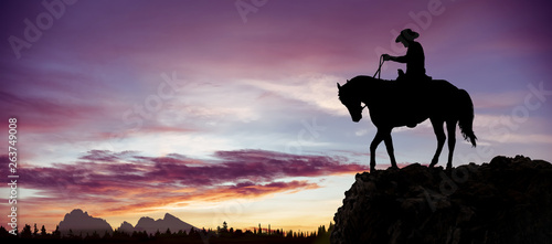Fotografía Silhouette of a cowboy on horseback observing the sunset from a rock overlooking the woods