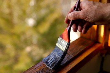 fragment of a man's hand with a brush. a man processes varnish of a window transom. a concept of rep