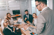 © Dusan Petkovic - Serious CEO talking to employees on business meeting in board room. You don't dram about success, you work for it.