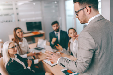 Serious CEO talking to employees on business meeting in board room. You don't dram about success, you work for it.