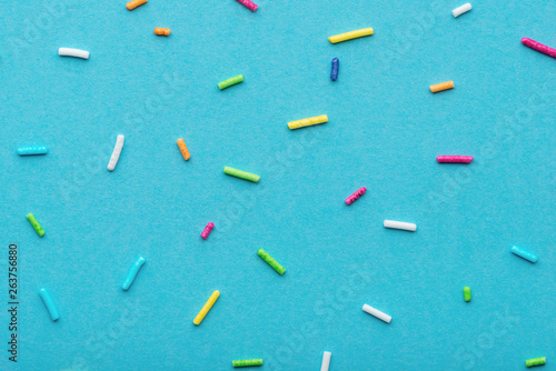 flat lay of colorful sprinkles over blue background, festive decoration for V...
