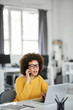© nenadaksic - Charming mixed race businesswoman dressed casual using smart phone and laptop at the same time while sitting in modern office.