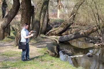 Wall Mural - A young man videotaping on a smartphone. Uses gimbal to get smooth footage. Closely watching the movie shooting.