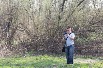 Wall Mural - A young man videotaping on a smartphone. Uses gimbal to get smooth shots. Controls the recording by touching the screen.