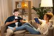 © Syda Productions - leisure and people concept - couple with tablet computer, headphones and book at home in evening