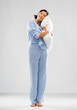 © Syda Productions - people and bedtime concept - happy young woman in blue pajama hugging pillow over grey background