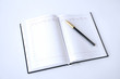 © amdre100 - An open notebook and pen on a white background