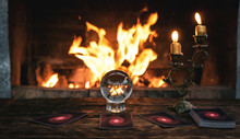 Tarot Cards And Crystal Ball On Fortune Teller Table On A Burning Fire Background. Futune Reading Concept. Divination.