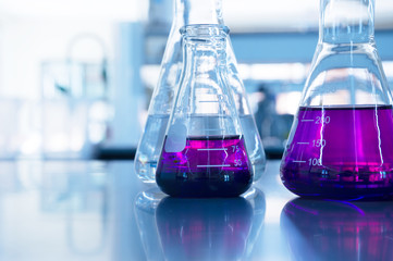 Wall Mural - chemical purple water solution in glass flask at education science laboratory background