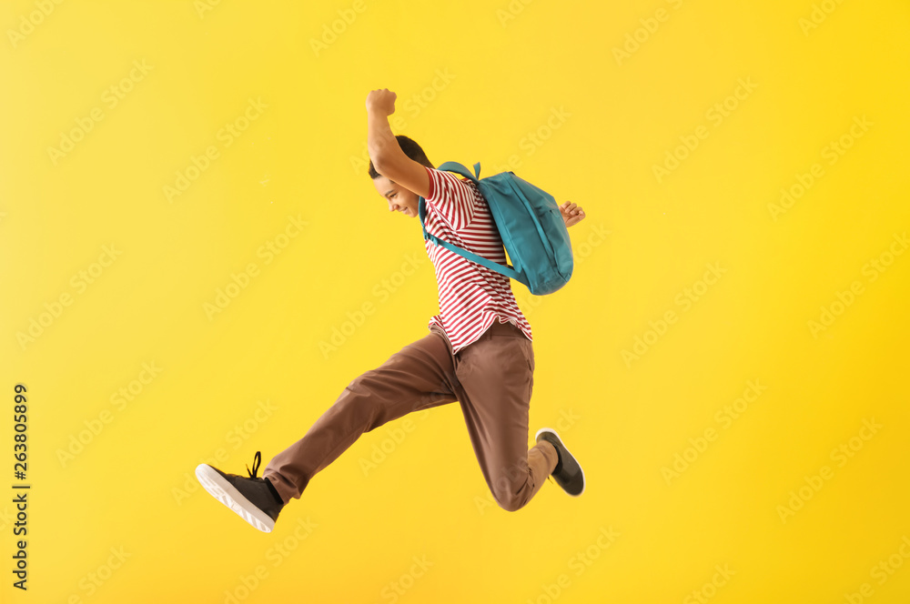 Portrait of jumping African-American teenage boy on color background - obrazy, fototapety, plakaty 