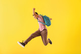 Portrait of jumping African-American teenage boy on color background