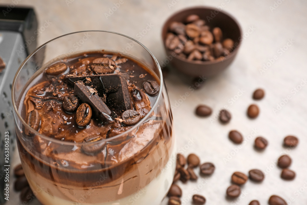 Glass of delicious panna cotta on grey table