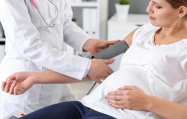 Poster - Young pregnant woman visiting her gynecologist in clinic