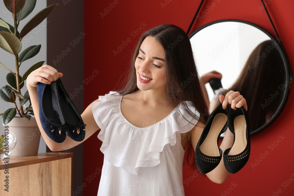Young woman choosing shoes in dressing room