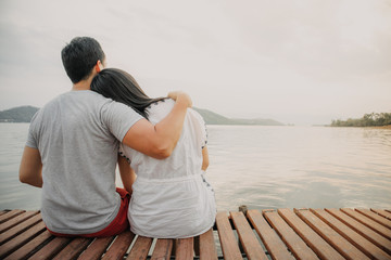 Lover couple hold together and admire the romantic beautiful lake landscape.