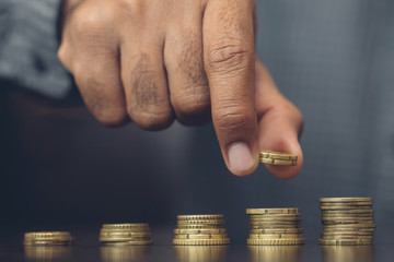 Saving money. businessman hand putting stack coins to show concept of growing savings money finance business and wealthy. 