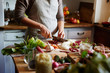 © Trinette Reed/Stocksy - Woman chopping vegetables while cooking