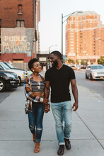 A Young Black Couple Walking Around The City At Sunset