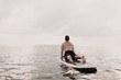© Leah Flores/Stocksy - Man Doing Yoga on Paddleboard