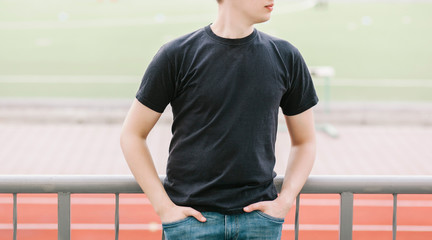 Wall Mural - A stylish man in a black T-shirt. Street photo