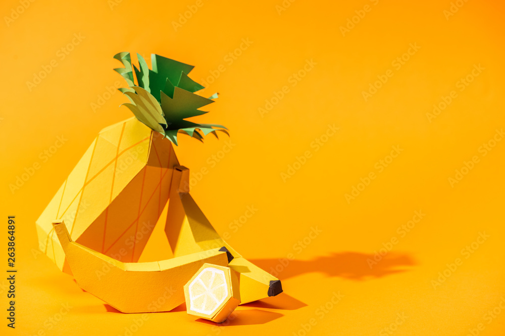 handmade paper pineapple, bananas and lemon on orange with copy space - obrazy, fototapety, plakaty 