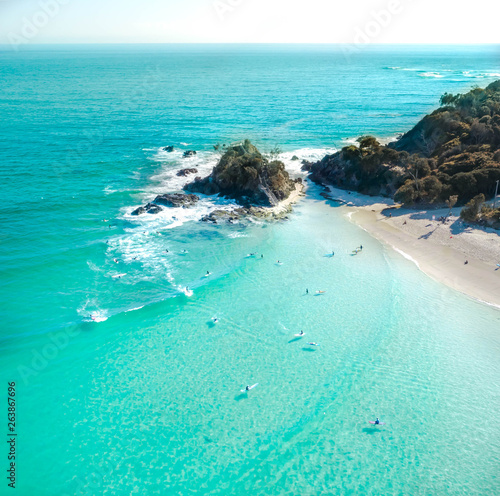 Cuadros en Lienzo Aerial shot at sunrise over the ocean and white sand beach with swimmers and sur