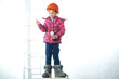© Roman - Little girl electrician in a construction helmet with a light bulb.