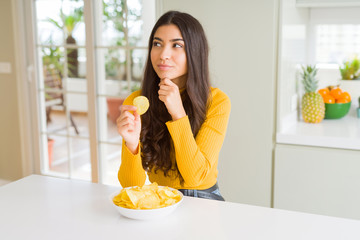 Poster - Young woman eating fastfood potato chips serious face thinking about question, very confused idea