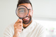 © Krakenimages.com - Handsome man using magnifying glass, doing funny faces