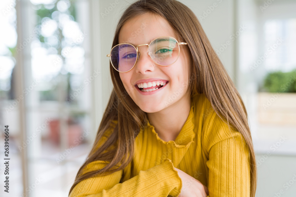 Beautiful young girl kid wearing glasses with a happy and cool smile on face. Lucky person.