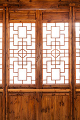 Wall Mural - Closeup Chinese old wooden frame door with decorative pattern under the sunshine ,view from inside of building.