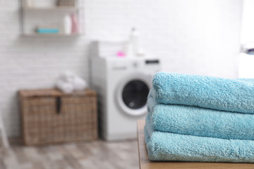 Sticker - Stack of towels on table against blurred background, space for text