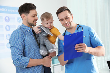 Canvas Print - Father with child visiting doctor in hospital