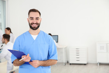 Canvas Print - Portrait of medical student with clipboard in scientific laboratory. Space for text