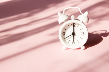 Wall Mural - Alarm clock on pink background. Morning time background concept