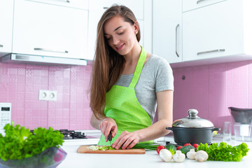 Wall Mural - Cooking woman chopping ripe vegetables for healthy fresh salads and dishes in kitchen at home. Clean food and proper nutrition. Cooking preparation for dinner