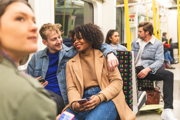 Multiracial couple travelling by tube together