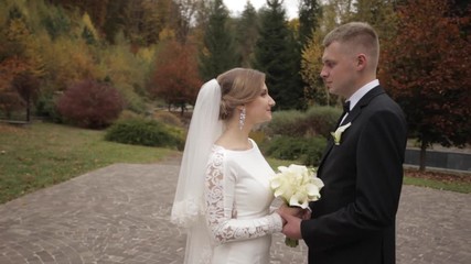 Wall Mural - Handsome groom and charming bride spend ti,e together after wedding ceremony in the park